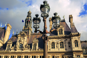 Naklejka premium Hotel de Ville in Paris, France. Historic building housing the city's local administration. Facade of city hall and vintage lantern in spring. French municipality.