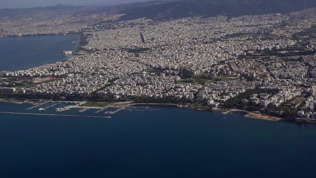 Aerial city day view taken from inside of inclining aircraft taking off from SKG international airport, Thessaloniki, Greece, Europe