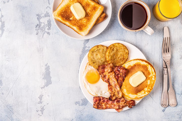 Healthy Full American Breakfast with Eggs Bacon Pancakes and Latkes.