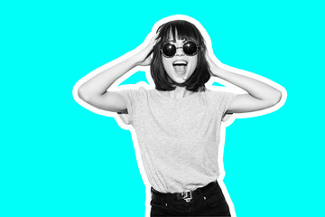 Collage in magazine style with colorful emotional fashion girl in t-shirt and sunglasses scream holding her head toned blue background