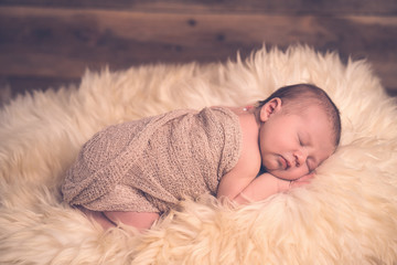 Fototapeta premium Close up süßes Neugeborenes Baby Junge Mädchen schläft friedlich auf Fell