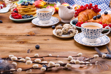 Fresh morning coffee and pastries homemade for breakfast. Delicious food for a romantic breakfast and spring flowers. The concept for Easter and home comfort.