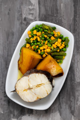 boiled fish with vegetables on white dish