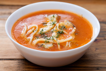 fish soup in the white bowl on wooden background