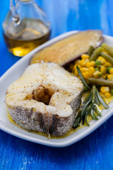 boiled fish with vegetables on white dish