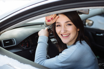 Fototapeta na wymiar Happy woman driving a car outdoors in winter