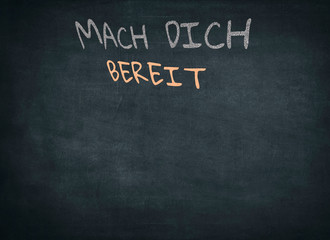 Fototapeta premium Conceptual Get Ready (Mach dich bereit) Message in German Texts Written on Black Chalkboard