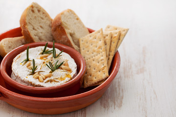 cheese camembert with nuts and rosemary in ceramic dish