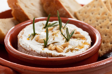 cheese camembert with nuts and rosemary in ceramic dish