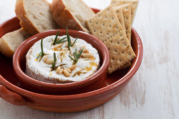 cheese camembert with nuts and rosemary in ceramic dish