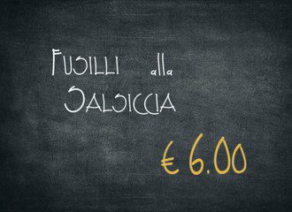 Offer of an Italian meal of Fusilli alla salsiccia for an amount of 6,00 euros. White words on a black chalkboard