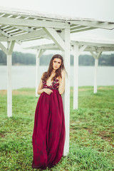 Fototapeta premium Freedom beauty young woman in sexy dress outdoors near the lake walking and posing