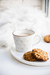 Cozy weekend breakfast with fur blanket, cup of coffee and cookies on ceramic tray