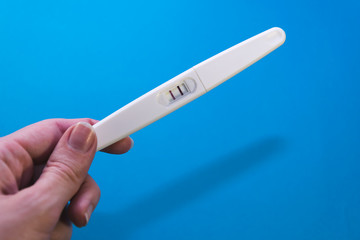 positive pregnancy test on a blue background