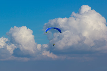 Clouds with unknown paraglider flying with instructor