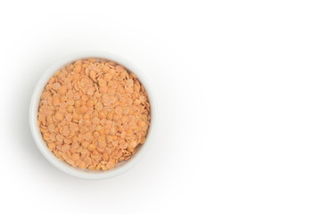 Husked split red lentils in white bowl.