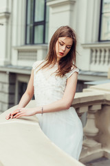 Gorgeous elegant caucasian young lady posing outdoors in old town in fashionable wedding dress. Beauty, fashion, vogue concept