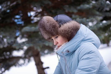 a woman in a fur hat and a light jacket on winter street