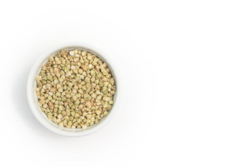green buckwheat on grey table in white bowl