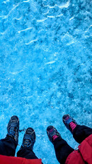 Fototapeta premium Couple standing on glacier ice surface wearing crampons