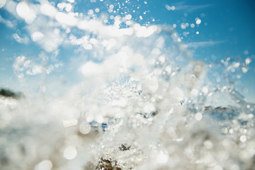 Summer swimming concept. Water splashes in sunlight and blue sky. Selective focused image.