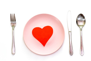 Valentines day (or wedding) set with fork, spoon and knife, paper heart on white background, top view.
