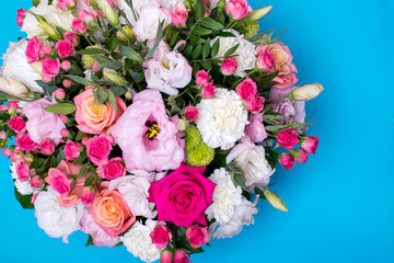 beautiful floral arrangement, pink and yellow rose, pink eustoma, green and pink chrysanthemum, white carnation, pink dahlia on a blue, turquoise background with space for text.