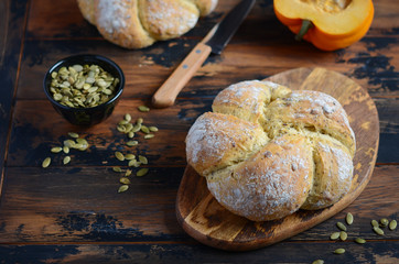 Freshly baked pumpkin bread with seeds on wooden cutting board.