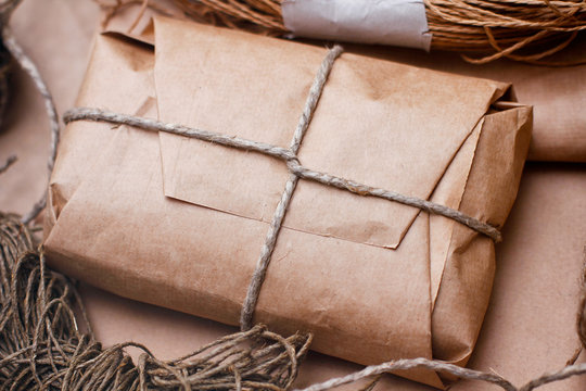Box parcel wrapped in craft brown paper  tied by hemp rope. Set of cords balls. Bundles  of threads.