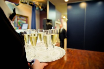 Waiters serving glasses of champagne to the guests at a party.