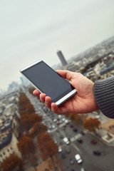 Modern man enjoying the view and using cellphone in the European city.