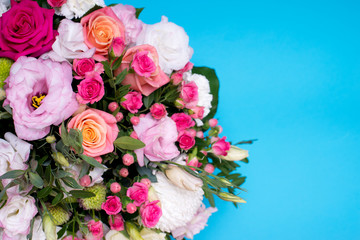 beautiful floral arrangement, pink and yellow rose, pink eustoma, green and pink chrysanthemum, white carnation, pink dahlia on a blue, turquoise background with space for text.
