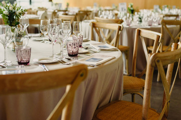 Fototapeta na wymiar Tables and wooden chairs arranged and decorated in a wedding hall of a hotel
