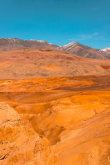 Naklejka na ściany i meble Yellow and red rocks under blue sky. Desert landscape with mountains.