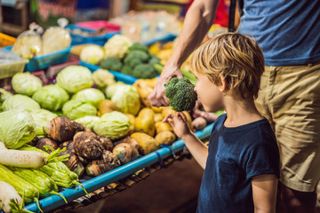 Dad and son are tourists on Walking street Asian food market