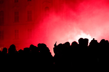 Silhouette of a crowd of football (soccer) fans celebrating the victory of teams and firing...