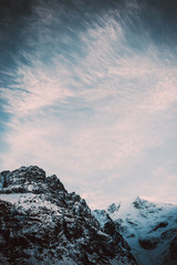 Severe mountain peaks under snow. Dark atmosphere of nature.