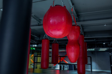 Red punching bags with gym background. Pears for boxing