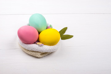 Colored eggs lie on a light wooden background, Concept illustration for Easter