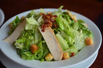 Healthy Caesar salad made of fresh vegetables , chicken and bacon.