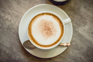 Hot coffee and hot tea place on the marble table in early morning with copyspace, white cup and silver spoon.