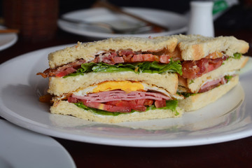 Close up of banh mi, a French Vietnamese layered sandwich with ham, egg and roasted pork in a baguette