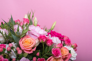 beautiful floral arrangement in the box, pink and yellow rose, pink eustoma, green and pink chrysanthemum, white carnation, pink dahlia on pink background with space for text.