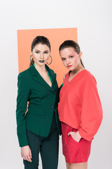 beautiful trendy young women looking at camera and posing with living coral on background
