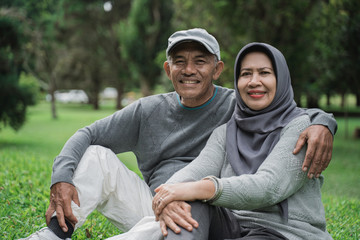 muslim couple in the park smiling and looking at camera