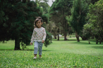 cute young kid walking in the park 