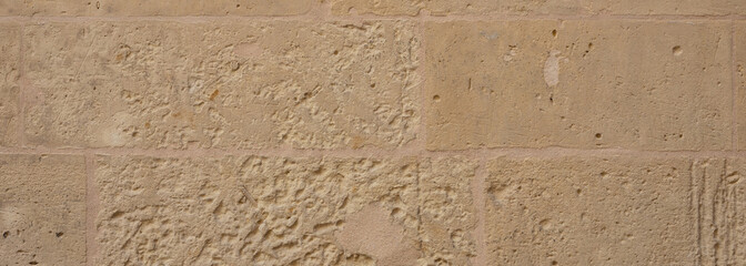 Traditional limestone wall facade background in Malta, banner