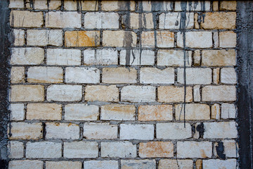 Old and weathered grungy yellow and white brick wall as seamless pattern texture background.