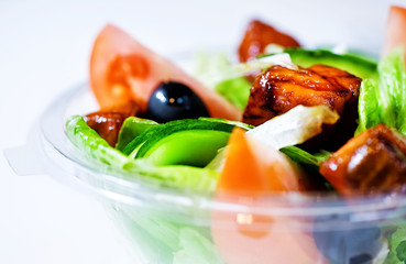 Delicious salad with meat, tomatoes and greenery on white