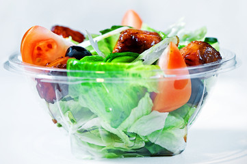 Delicious salad with meat, tomatoes and greenery on white